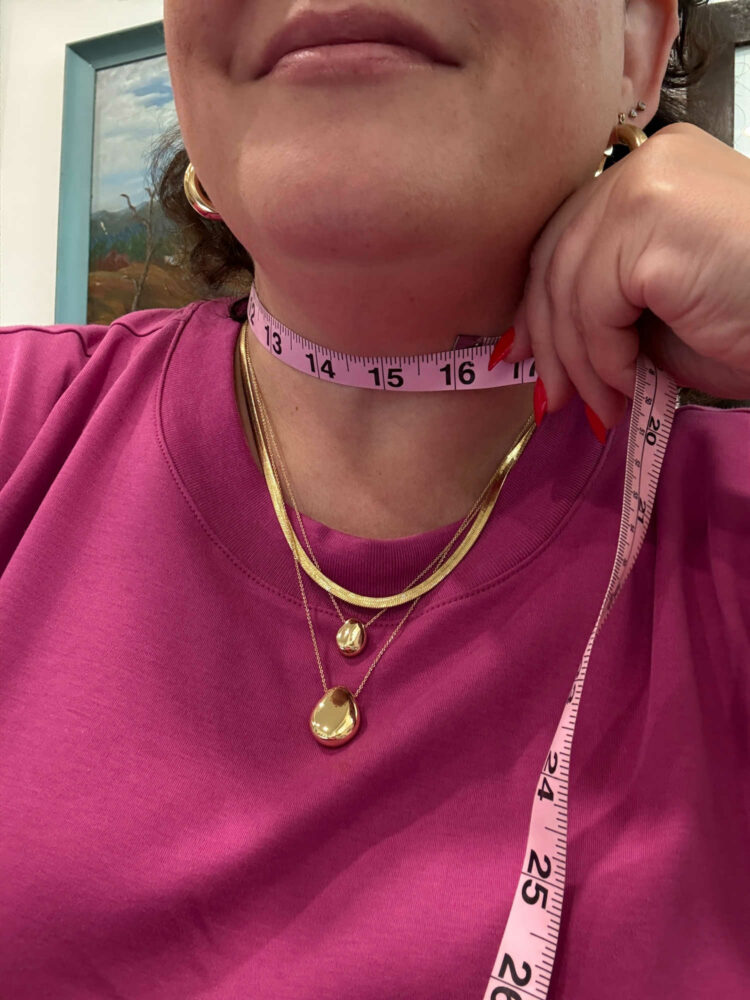 woman with a tape measure around her neck showing the neck is 16" in size