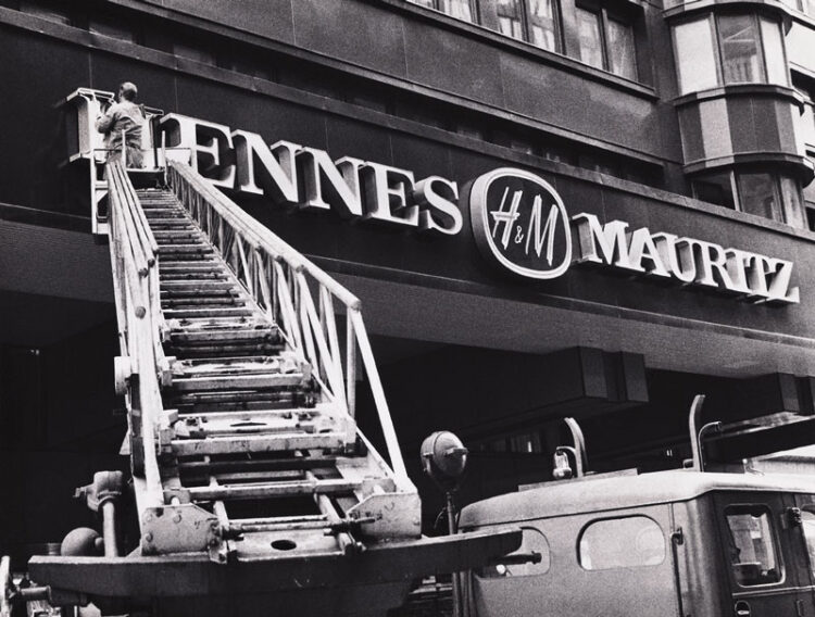 H&M A ladder changing the name of a storefront from Hennes to Hennes Mauritz with the H&M logo