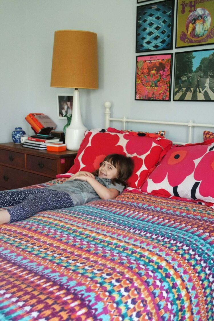 a bed covered with Marimekko sheets and a rainbow quilt | A Colorful Journey