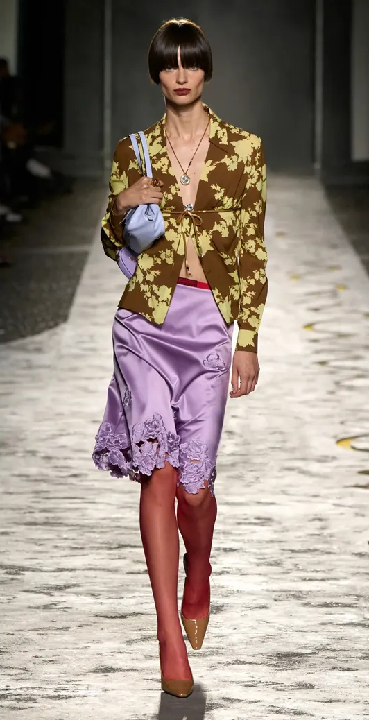 A runway look from Versace featuring a lace-trimmed silk skirt