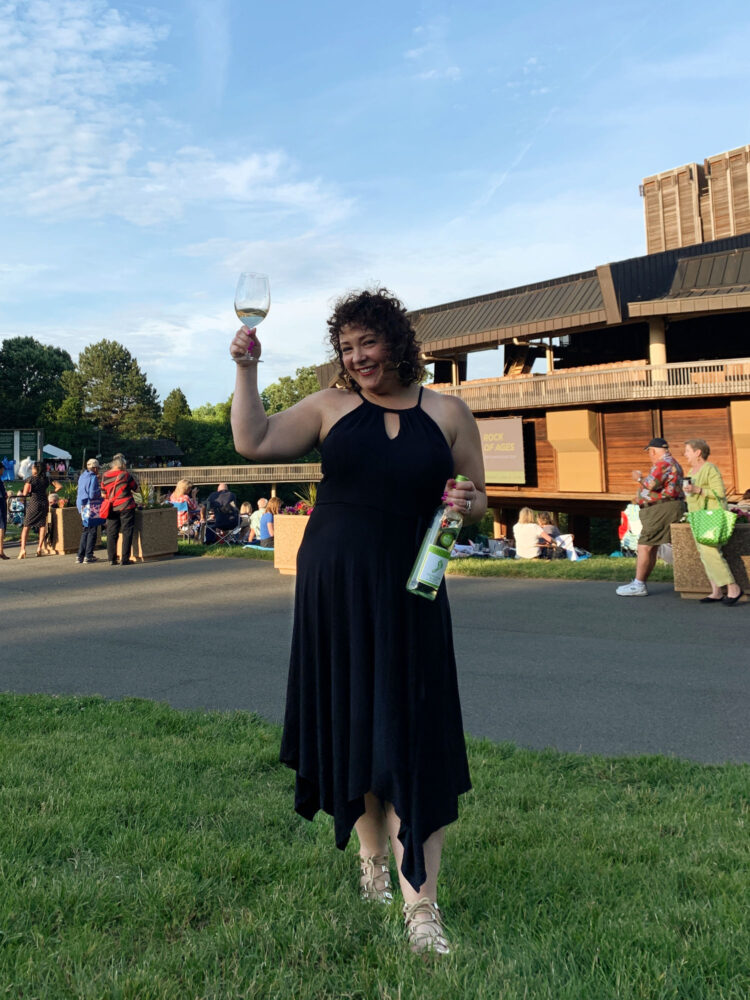 Woman at Wolf Trap for Johnny mathis wearing a black knit dress and flat sandals